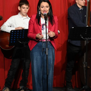 zena u crvenom sakou prica ispred mikrofona