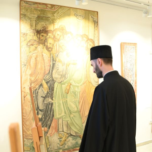 svestenik gleda u ikonu