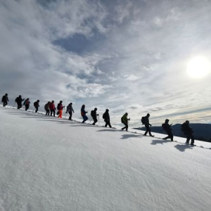 kolona ljudi se krece po snegu